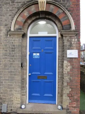 a blue door in a brick building with an arch at The Tas Suites - Tas Accommodations in Cambridge