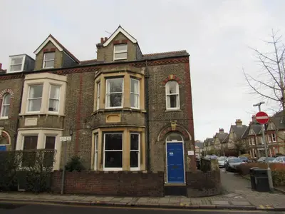 a brick house with a blue door on a street at The Tas Suites - Tas Accommodations in Cambridge