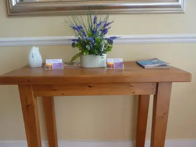 a wooden table with a vase of flowers on it at WynnStay Studio Apartments in Southend-on-Sea