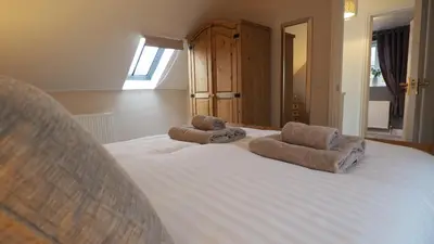 a bedroom with a bed with towels on it at Woodlands View in Halesworth