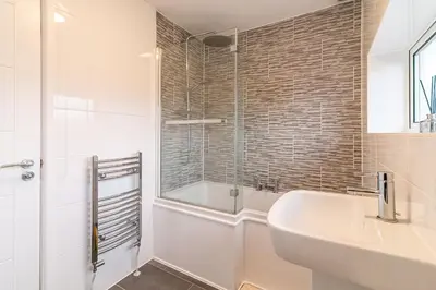 a bathroom with a tub and a sink and a shower at Denby Lodge in Letchworth