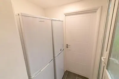 a white refrigerator in a room with a door at Denby Lodge in Letchworth