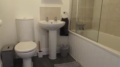 a bathroom with a toilet and a sink and a shower at Hideaway Cottage in Halesworth