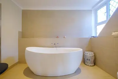 a white tub in a bathroom with a window at Turret House, Thorpeness - Close to the beach, Thorpeness Lake , Thorpeness Hotel, Golf and Country Club - Aldeburgh Coastal Cottages in Thorpeness