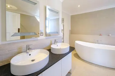 a bathroom with two sinks and a large mirror at Turret House, Thorpeness - Close to the beach, Thorpeness Lake , Thorpeness Hotel, Golf and Country Club - Aldeburgh Coastal Cottages in Thorpeness