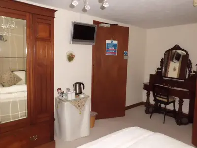 a bedroom with a bed and a table and a piano at The Elms in East Harling