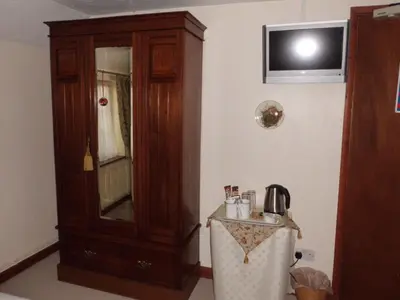 a bathroom with a wooden cabinet and a sink at The Elms in East Harling