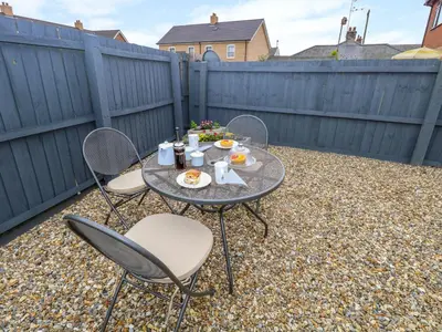 a table and chairs with food on a patio at Village Retreat in Ely