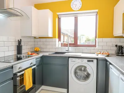 a kitchen with a washing machine and a window at Village Retreat in Ely