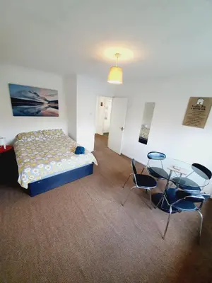 a bedroom with a bed and a table and chairs at 2 Bedroom Rayleigh Apartment in Rayleigh