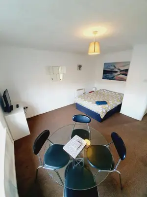 a room with chairs and a table and a bed at 2 Bedroom Rayleigh Apartment in Rayleigh
