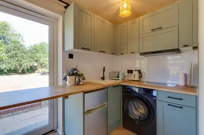 a kitchen with a washing machine and a window at Pass the Keys Charming and Central Garden Studio Flat Free Parking in Cambridge