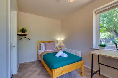 a small bedroom with a bed and a window at Pass the Keys Charming and Central Garden Studio Flat Free Parking in Cambridge