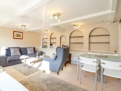 a living room with a couch and a table at Vine Cottage in Halstead