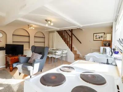 a living room with a couch and a table at Vine Cottage in Halstead