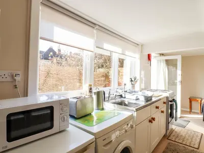 a kitchen with a sink and a microwave at Vine Cottage in Halstead