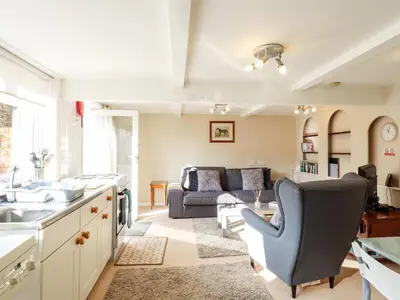 a kitchen and living room with a couch at Vine Cottage in Halstead