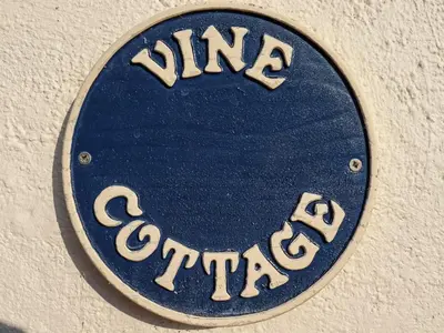 a sign on the side of a building at Vine Cottage in Halstead