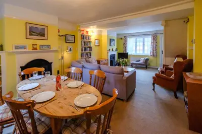 a living room with a wooden table and a couch at 4 Old Homes, Thorpeness - Only a stones throw from the beach - Aldeburgh Coastal Cottages in Thorpeness