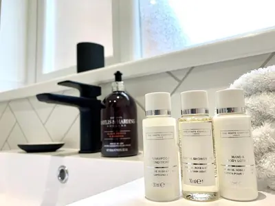 three bottles of hair products sitting on a bathroom counter at Stylish Cambridge Pad in Bar Hill