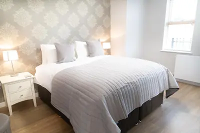 a bedroom with a large bed with a white comforter at Citystay Living - Hinton House in Cambridge
