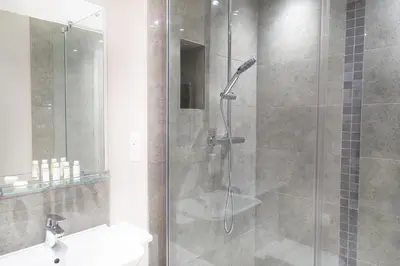 a bathroom with a shower with a toilet and a sink at Citystay Living - Hinton House in Cambridge