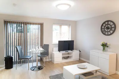 a living room with a tv and a table and chairs at Citystay Living - Hinton House in Cambridge