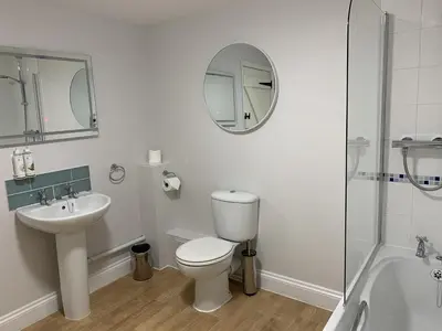 a bathroom with a toilet and a sink and a mirror at Kings Head Low House in Laxfield
