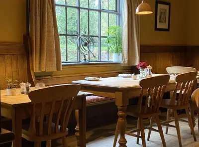 a dining room with a table and chairs and a window at Kings Head Low House in Laxfield
