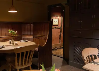 a dining room with a wooden table and chairs at Kings Head Low House in Laxfield