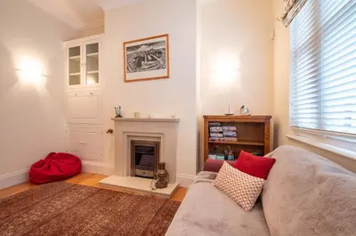 a living room with a couch and a fireplace at Polly's - Aldeburgh Coastal Cottages in Aldeburgh