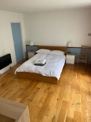 a bedroom with a large bed and a wooden floor at Wood Place in Diss