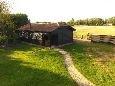 a small house in a field with a path leading to it at Church Farm Lodge in Southburgh