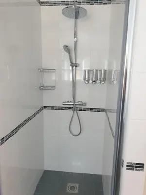 a shower with a shower head in a bathroom at Church Farm Lodge in Southburgh