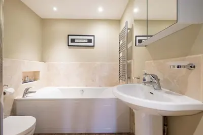 a bathroom with a tub and a sink and a toilet at Beachcomber - Aldeburgh Coastal Cottages in Aldeburgh