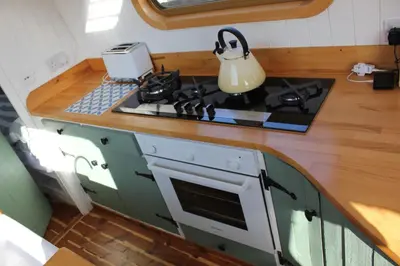 a kitchen with a stove and a counter top at Waterbeach Boatel in Cambridge
