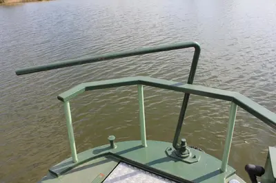 a boat with a rail on the water at Waterbeach Boatel in Cambridge