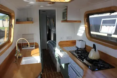 a kitchen with a sink and a stove in an rv at Waterbeach Boatel in Cambridge