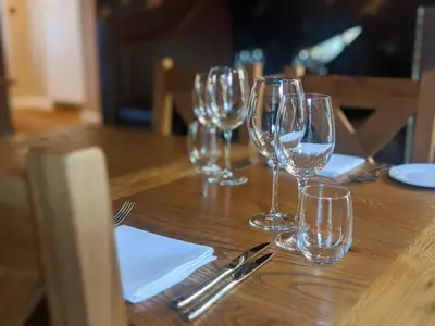 a group of wine glasses sitting on a wooden table at The Bell Inn in Thorpe le Soken