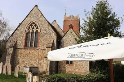 an umbrella in front of a church at The Bell Inn in Thorpe le Soken