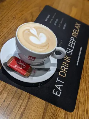 a cup of coffee on a plate on a table at The Bell Inn in Thorpe le Soken