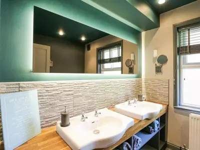 a bathroom with two sinks and a large mirror at Saxon Lodge Cottage in Felixstowe