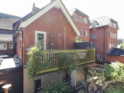 a view of a house with a wooden balcony at Saxon Lodge Cottage in Felixstowe