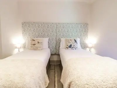 two beds sitting next to each other in a room at Saxon Lodge Cottage in Felixstowe