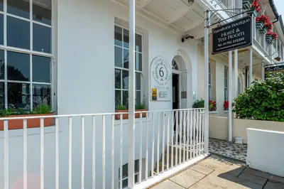 a white building with a sign in front of it at Hamiltons Boutique Hotel in Southend-on-Sea