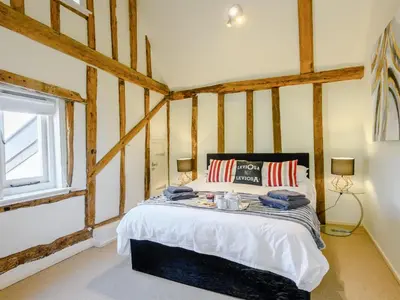 a bedroom with a bed in a room with wooden beams at Laurel Barn in Ashwellthorpe