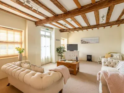 a living room with two couches and a tv at Laurel Barn in Ashwellthorpe
