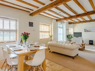 a living room with a table and a couch at Laurel Barn in Ashwellthorpe