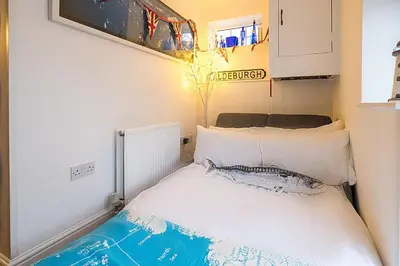 a small bedroom with a bed with white pillows at 69 Saxmundham Road in Aldeburgh