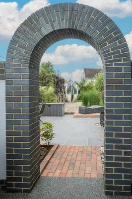 an arched brick archway over a patio at 69 Saxmundham Road in Aldeburgh